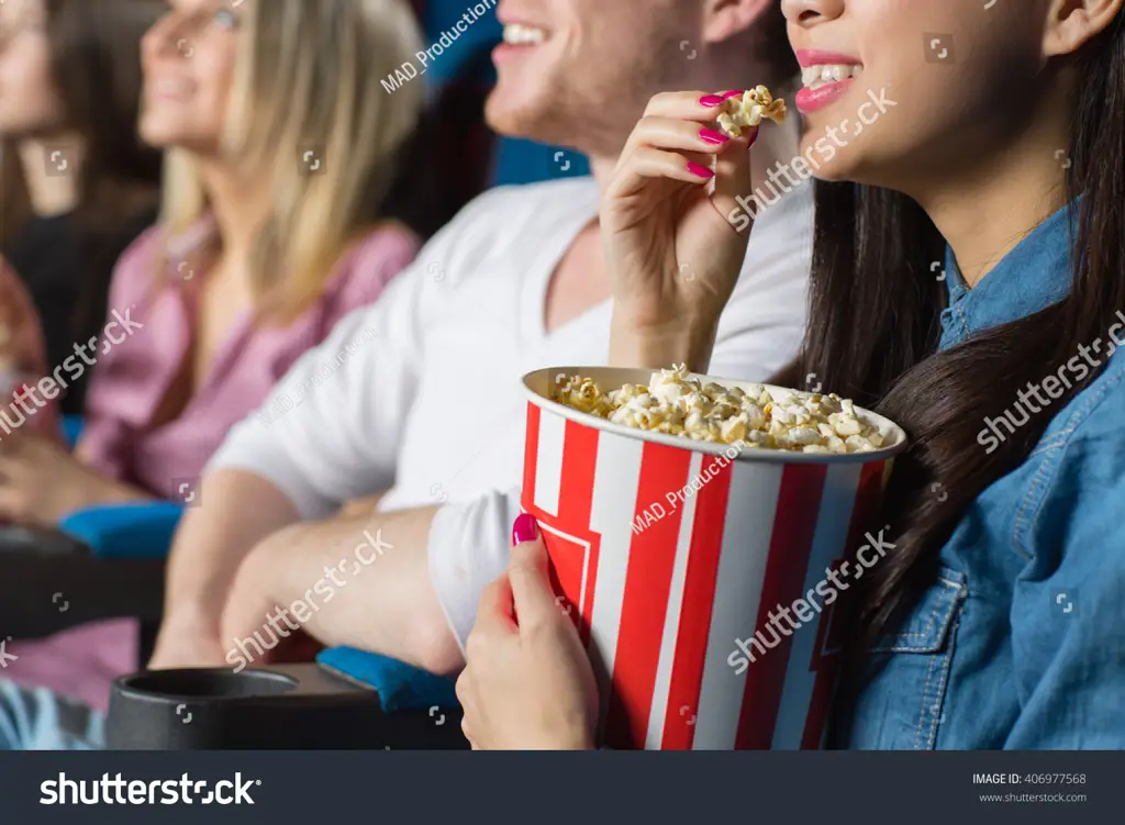 Nikmati popcorn dan minuman favoritmu saat menonton Segelas minuman dan sebungkus popcorn di bioskop